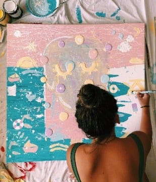 Artist working on a large colourful canvas
